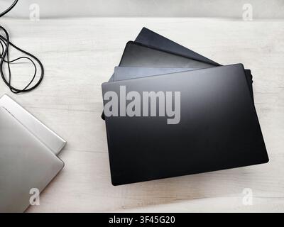 stack of laptops on a gray background, on the table, laptop computer, tablet, business, work, remote work, freelance. Stock Photo