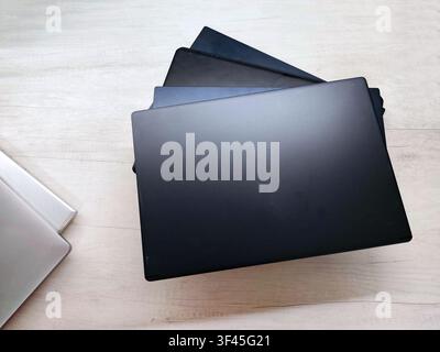 stack of laptops on a gray background, on the table, laptop computer, tablet, business, work, remote work, freelance. Stock Photo