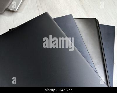 stack of laptops on a gray background, on the table, laptop computer, tablet, business, work, remote work, freelance. Stock Photo