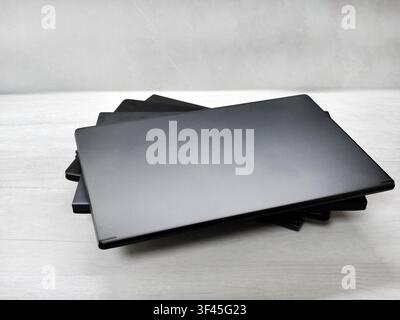 stack of laptops on a gray background, on the table, laptop computer, tablet, business, work, remote work, freelance. Stock Photo