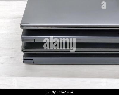 stack of laptops on a gray background, on the table, laptop computer, tablet, business, work, remote work, freelance. Stock Photo