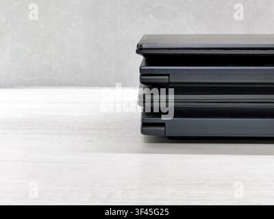 stack of laptops on a gray background, on the table, laptop computer, tablet, business, work, remote work, freelance. Stock Photo