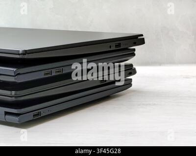 stack of laptops on a gray background, on the table, laptop computer, tablet, business, work, remote work, freelance. Stock Photo