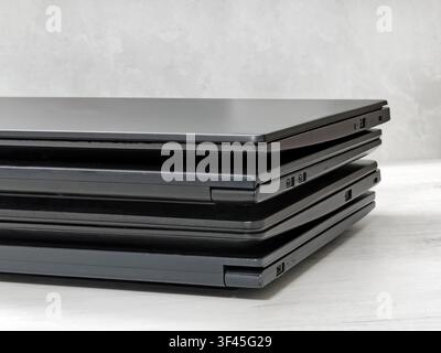 stack of laptops on a gray background, on the table, laptop computer, tablet, business, work, remote work, freelance. Stock Photo