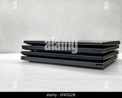 stack of laptops on a gray background, on the table, laptop computer, tablet, business, work, remote work, freelance. Stock Photo