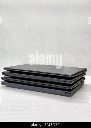 stack of laptops on a gray background, on the table, laptop computer, tablet, business, work, remote work, freelance. Stock Photo