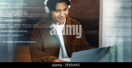 Focused Young Male Student Using Laptop And Headphones At Home Office, Technology Concept Stock Photo
