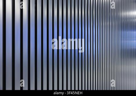Minimal architectural detail showing vertical metal lines and repeating stripes with blue-gray gradient tones. Clean modern texture ideal for backgrou Stock Photo