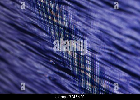 Macro view of a blue pixelated screen display revealing RGB subpixel structure and diagonal lines, creating an abstract textured pattern ideal for tec Stock Photo
