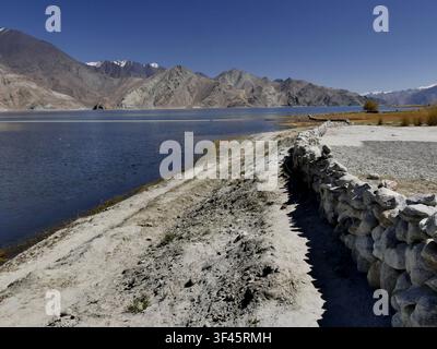 idyllic ladakhi landscape with stone wall along the lakeshore of Pangong tso in Changtang region in the Himalayas, north india Stock Photo