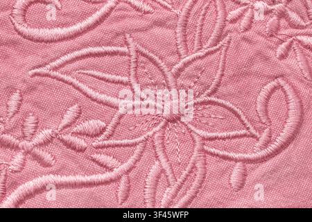 Pastel pink floral embroidery on cotton fabric closeup as a background Stock Photo