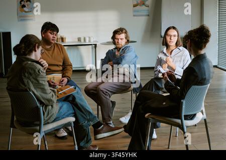 Diverse Adults Discussing Recovery Goals in Counseling Circle Stock Photo