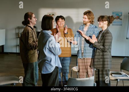 Diverse Young Adults Applauding during Group Therapy Support Session Stock Photo