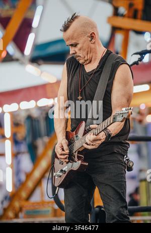 Focused musician plays electric guitar on stage Stock Photo