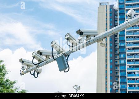 Multiple surveillance cameras installed above modern city street in Shenzhen, China. Smart city infrastructure, public safety, urban security, traffic Stock Photo