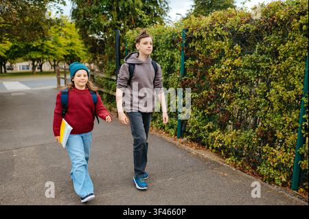Boy and girl walking near the entrance to a school Stock Photo