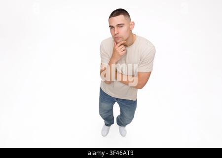 Above, thinking and why with man in studio for decision, remember or problem solving. Doubt, solution and question with confused person isolated on wh Stock Photo