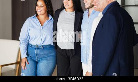Multi generational workers smiling in front of camera inside business office - Multiracial entrepreneur and teamwork concept - Main focus on asian gir Stock Photo