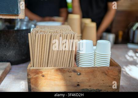 Stack of paper cups and biodegradable paper straws at cafe counter. Eco friendly, zero waste, and sustainable lifestyle concept. Stock Photo