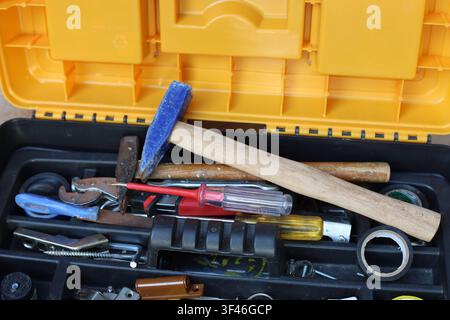 Open toolbox filled with various hand tools including hammer screwdriver and tape high angle view Stock Photo