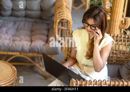 Asian professional analyzing information while using a laptop. Business planning, problem solving and productivity concept. Stock Photo