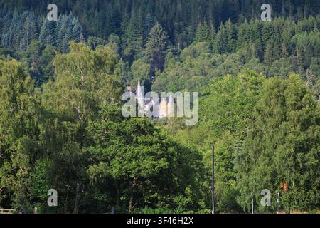 HPB Tigh Mor holiday resort partially hidden among woodland, viewed from the shores of Loch Achray in the Trossachs, Stirling, Scotland, UK. Stock Photo