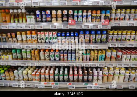 A wide variety of packaged salad dressings and cooking oils neatly arranged on shelves in a Japanese supermarket. Stock Photo