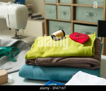 Sewing machine set up on white craft table ready for creative project. Stitch machine prepared with sewing equipment for productive craft work. Crafti Stock Photo