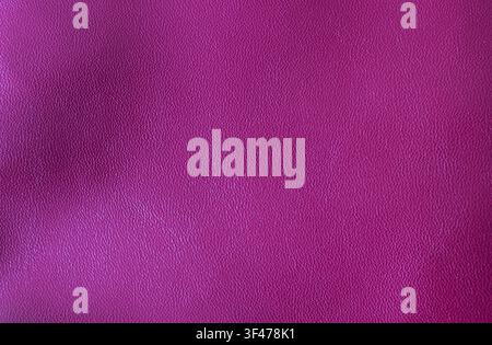 Close-up of raspberry synthetic leather with subtle embossed grain. Elegant textured background for luxury packaging, fashion, upholstery and design p Stock Photo