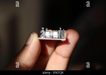 SMT electrolytic capacitors on motor driver board held in the hand Stock Photo