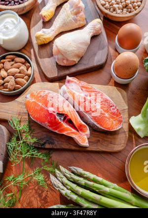 Top view of various healthy food ingredients, meat, fish, cereals and vegetables arranged on a wooden background. Stock Photo