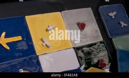 Handmade glazed ceramic tiles with relief doves, hearts and anchor motifs on a dark surface Stock Photo