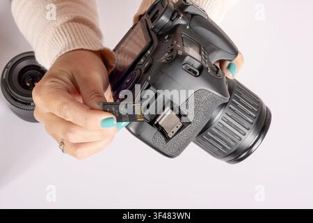 Inserting SD Memory Card into DSLR Camera Stock Photo