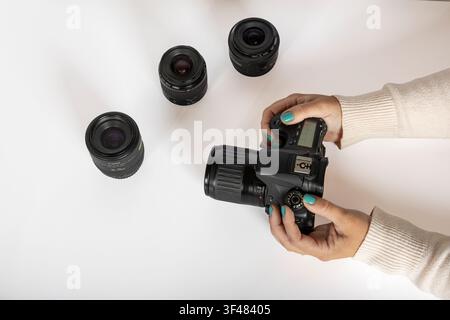 Reviewing DSLR Camera and Interchangeable Lenses on White Surface Stock Photo