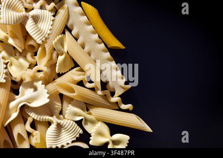 Different types of pasta on black background Stock Photo