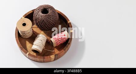 Natural Twine and Craft String Spools in Wooden Tray on Minimal Background Stock Photo