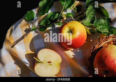 Single Organic Apple and Apple Half with Green Leaves on Rustic Table Stock Photo