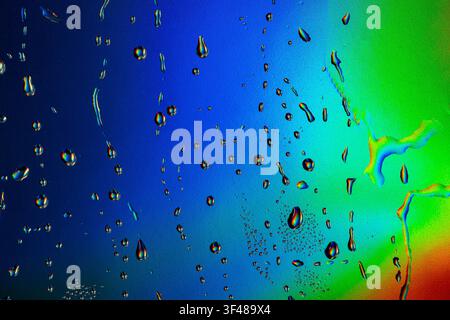 Close-up of vibrant neon water drops on a gradient background, creating a mesmerizing pattern. The vivid colors blend seamlessly, adding a dynamic, en Stock Photo