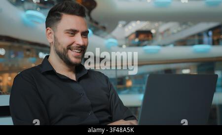 Smiling happy Caucasian businessman talking video call with laptop in business center man male guy employer worker talk conference with computer Stock Photo