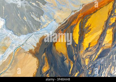 Vivid abstract landscape texture with flowing mineral-like layers in gold, blue, and sand tones, creating a vibrant nature-inspired wallpaper backgrou Stock Photo