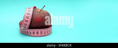 Fresh red apple wrapped with a measuring tape symbolizing healthy eating, weight loss, balanced nutrition, fitness, wellness, and lifestyle choices. Stock Photo