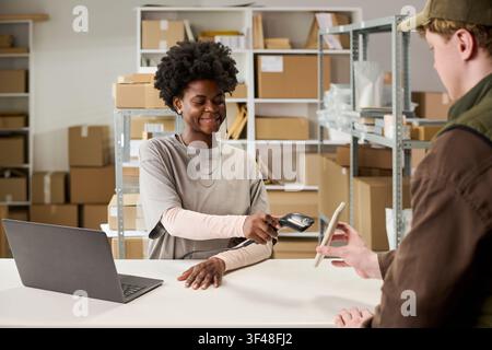 Black Woman Scanning Parcel for E Commerce Order Fulfillment Stock Photo