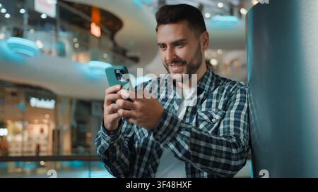 Happy smiling Caucasian business man guy using mobile phone social media scrolling online application smile cheerful male businessman browsing Stock Photo