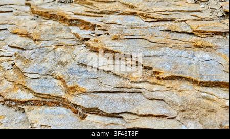 Close-Up of Golden Brown Slate Rock with Visible Layered Strata in the Swiss Alps Stock Photo