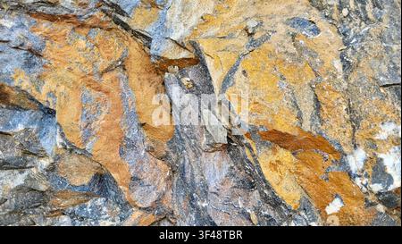 Close-Up of Gray Rock with Yellow Brown Rust-Colored Mineral Patterns in Switzerland Stock Photo