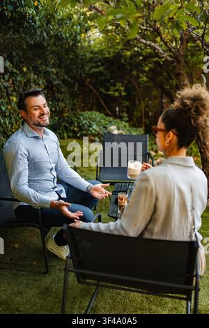 People having friendly conversation at outdoor coffee shop Stock Photo