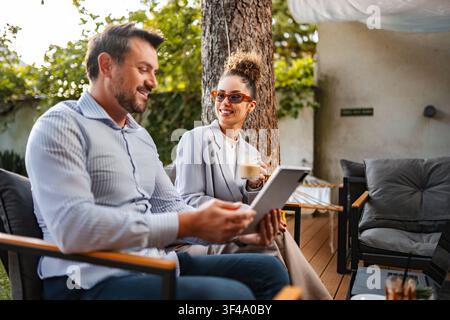 Couple discussing business outdoors using digital tablet Stock Photo