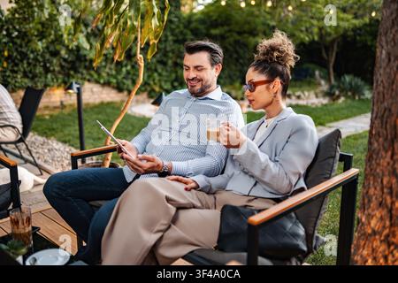 Business colleagues discussing project ideas using digital tablet outdoors Stock Photo