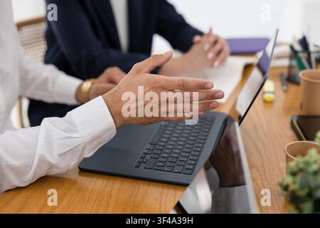 Business professionals discussing project using laptop Stock Photo