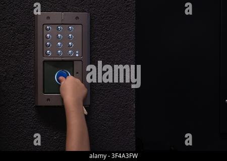 Person using video intercom keypad for secure building access Stock Photo